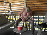 Older crossdresser sits on a big dildo